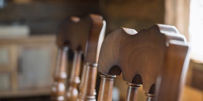 Handcrafted hardwood dining chair detail showing carved back design.
